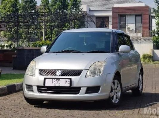 Mobil Suzuki Swift bekas warna merah tampak depan sebagai ilustrasi panduan mengecek penyakit Suzuki Swift bekas sebelum membeli